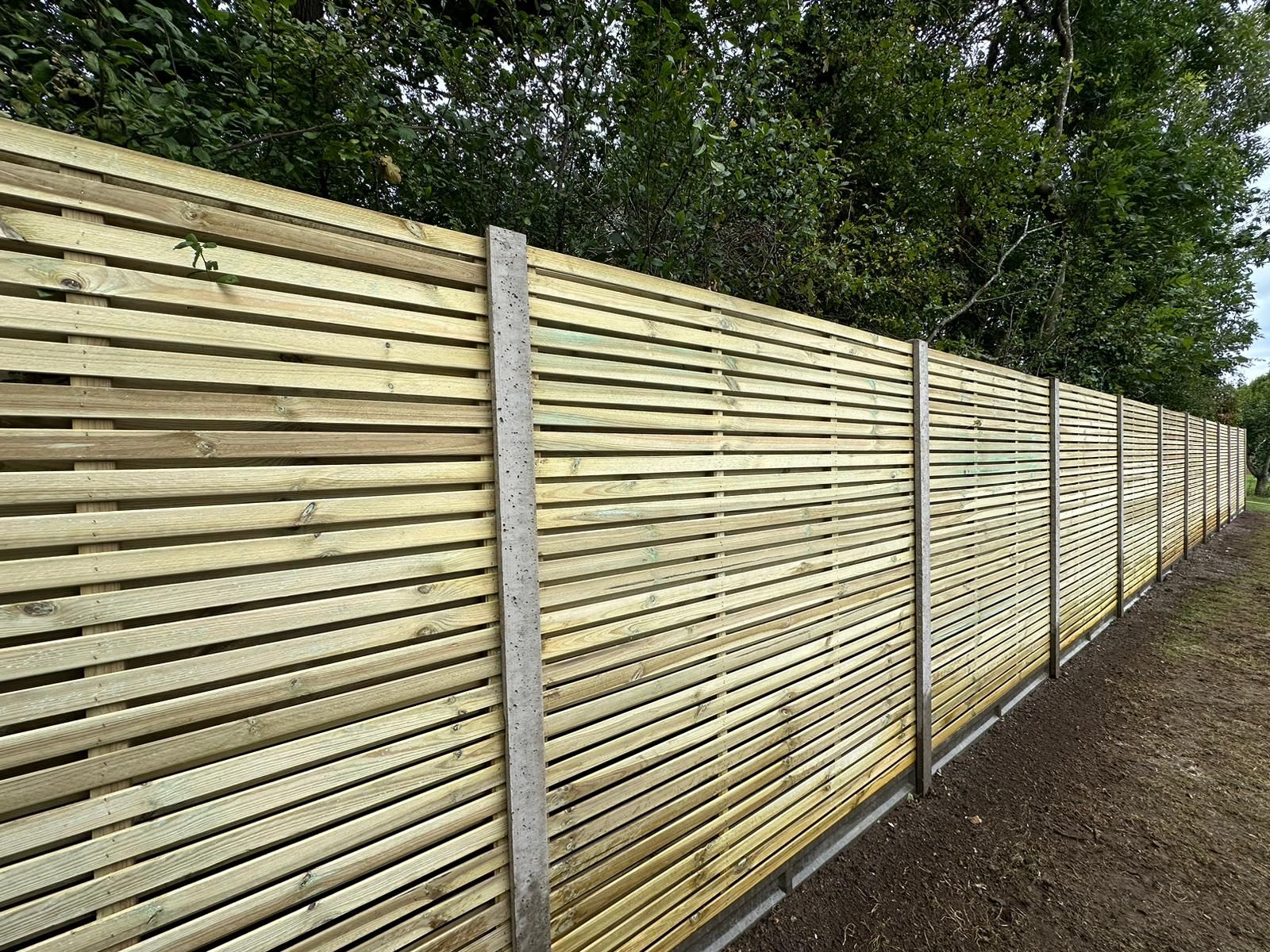 Long run of contemporary slatted fencing
